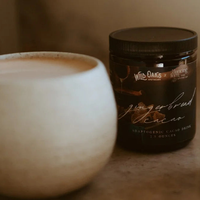 Jar of gingerbread spice mix next to a white mug on a wooden surface